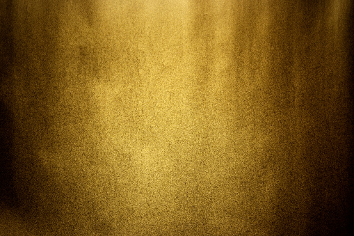 Close-up of dark gold texture background with spot light. 