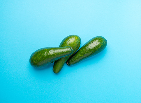 Avocado Isolated, Whole Avokado Set, Three Green Avocados Pile, Fresh Alligator Pear, Guacamole Ingredient, Long Avocado Fruit on Blue Background