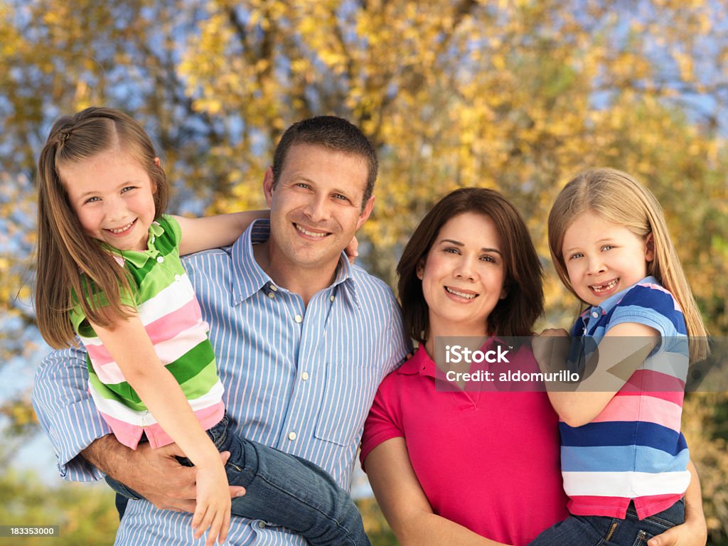 Joyful parents and daughters Joyful parents and daughters smiling at the camera Adult Stock Photo