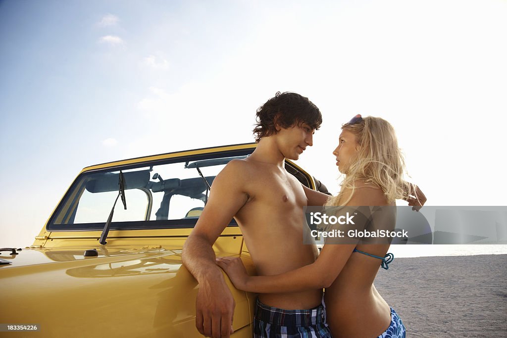 Romantique couple d'adolescents s'appuyant sur jeep sur la plage - Photo de 4x4 libre de droits