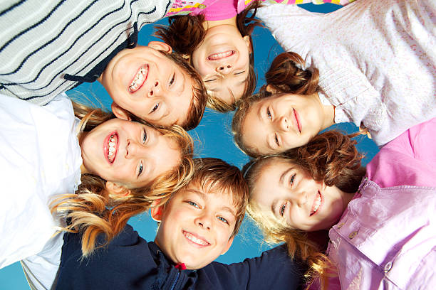 istock Low angle view of cheerful children huddling together 183354869