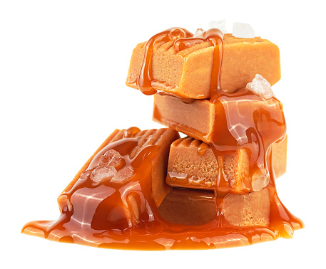 Caramel candies with melted caramel and sea salt isolated on a white background. Salted caramel pieces.