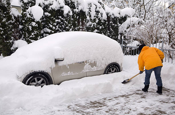 istock Woman shovelling around snow covered car 183355633