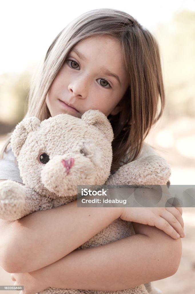 Triste joven Chica abrazándose edad, Raggedy Osito de peluche - Foto de stock de Niñas libre de derechos