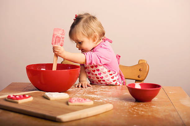 Kleines Mädchen zum Valentinstag Backen Kekse in der Küche – Foto