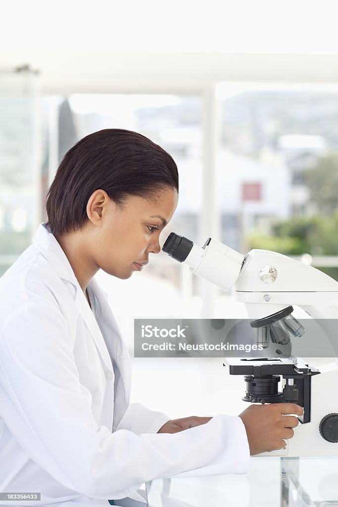 Scienziati che lavorano con un microscopio - Foto stock royalty-free di Laboratorio