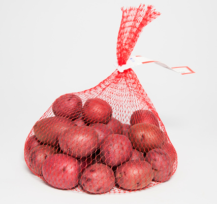 Plastic netting bag filled with tiny red potatoes.-For more fruits and vegetables, click here.  FRUITS and VEGETABLES 