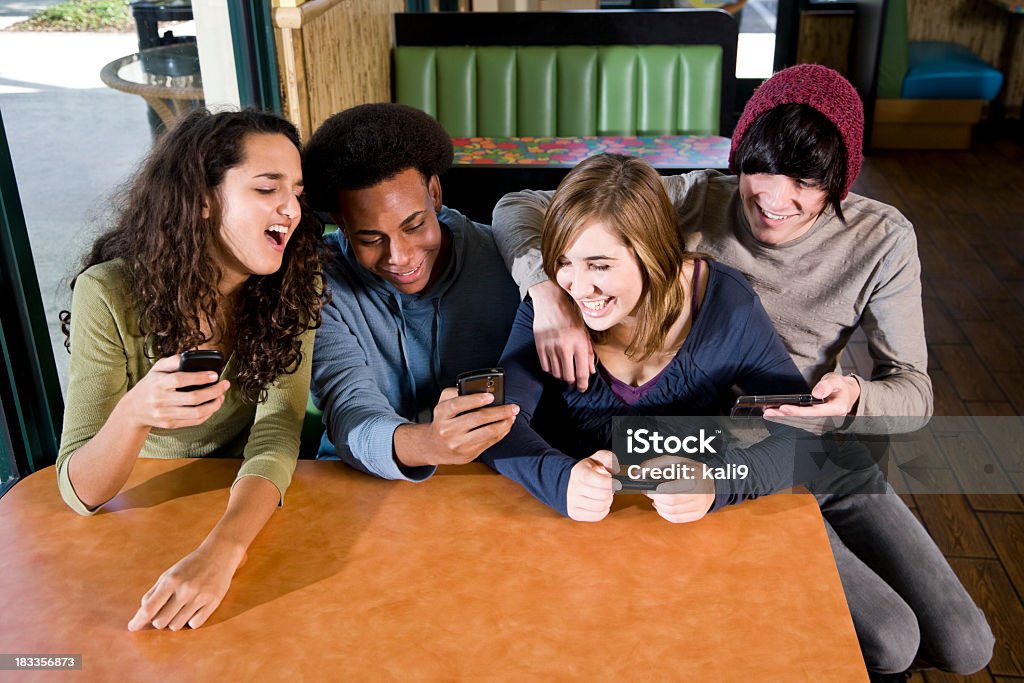 Multi-ethnique adolescents de diner à envoyer des SMS sur les téléphones mobiles - Photo de Adolescent libre de droits