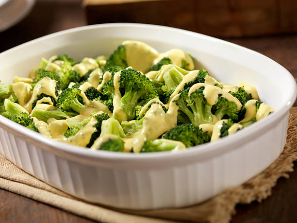 Steamed Broccoli with Cheese Sauce Steamed Broccoli with Cheese Sauce -Photographed on Hasselblad H3D2-39mb Camera cheese sauce stock pictures, royalty-free photos & images