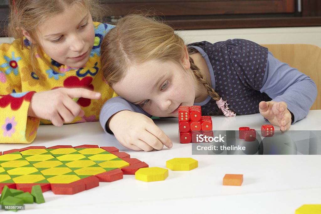 Two girls at school "Two young girls in a mathematics lesson at school, learning with cubes." Dice Stock Photo