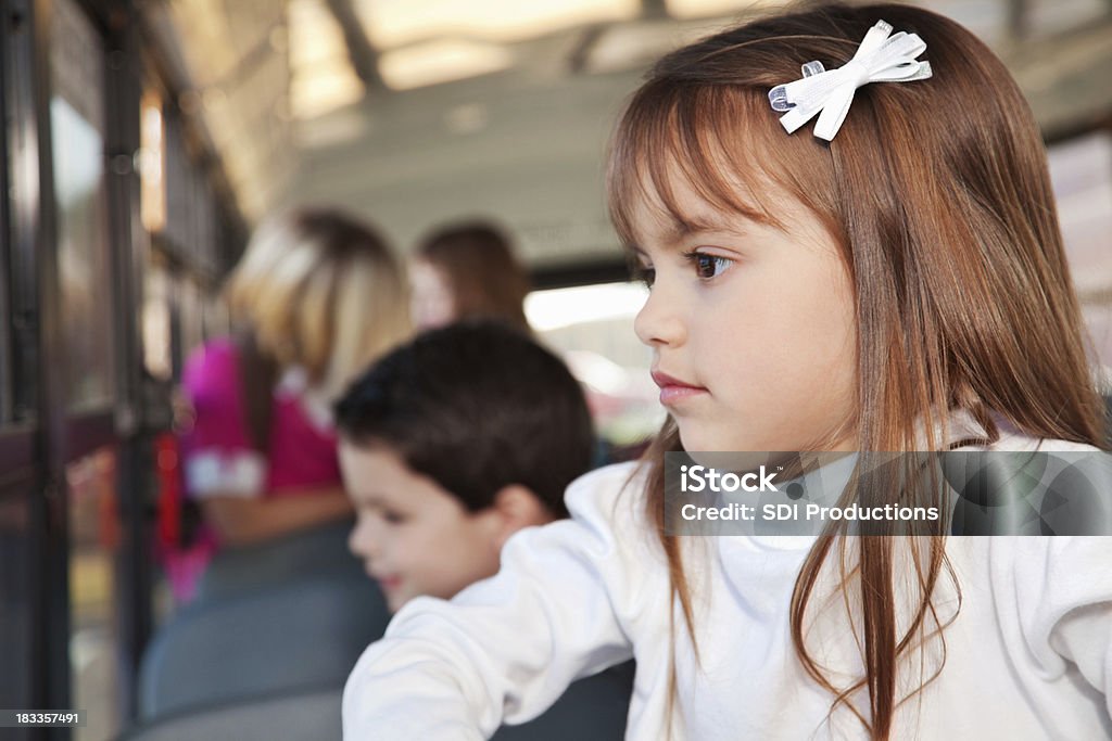 Petite fille regardant par sa fenêtre Bus scolaire - Photo de Bus scolaire libre de droits