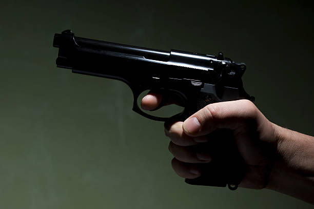 istock Gun and hand on the green background 183357520