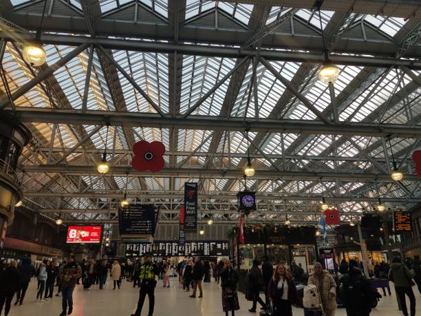 people are standing and walking inside an old historic central train station - glasgow central train station in glasgow scotland uk - plastic poppy imagens e fotografias de stock