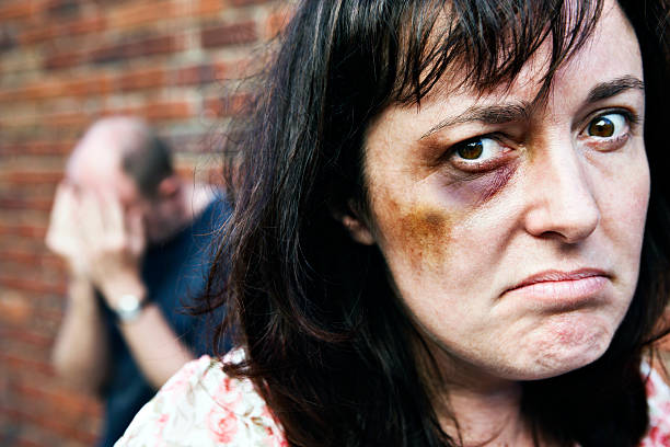 istock Enough! Angry battered woman glares; man has head in hands 183358657