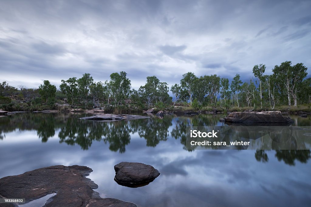 Billabong or small pond at Manning Gorge, Western Australia, dusk "Reflections in still water of a small lake with approaching storm clouds and thunderheads in the sky. Shot at Manning Gorge, along the Gibb River Road, Western Australia." Kimberley Plain Stock Photo