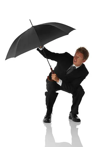 Photo of Businessman struggling with an umbrella