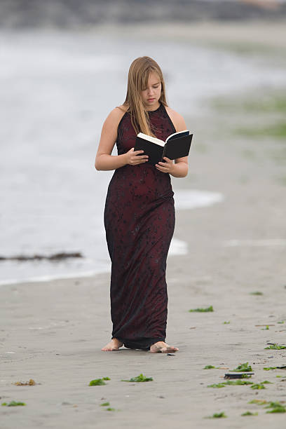 Young Girl reading a book while walking stock photo