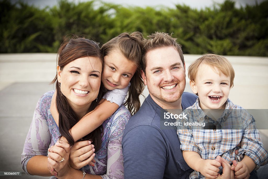 Familia joven feliz Riendo juntos al aire libre - Foto de stock de Felicidad libre de derechos