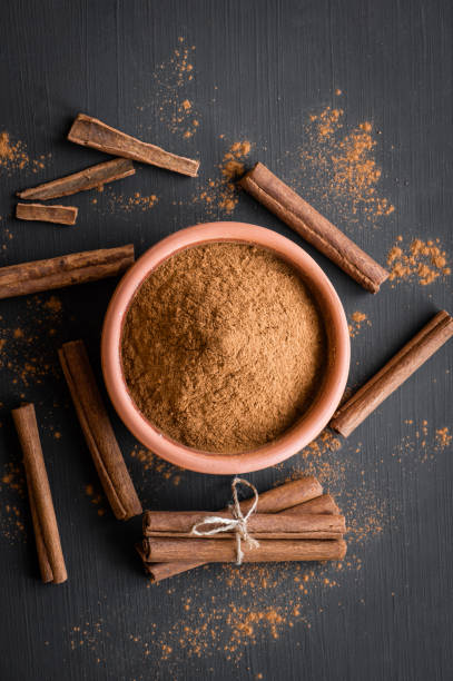 Cinnamon sticks and cinnamon powder on rustic background, healthy spice, (Cinnamomum)