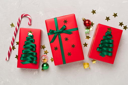 Creative handmade christmas gift boxes with decor on concrete background, top view