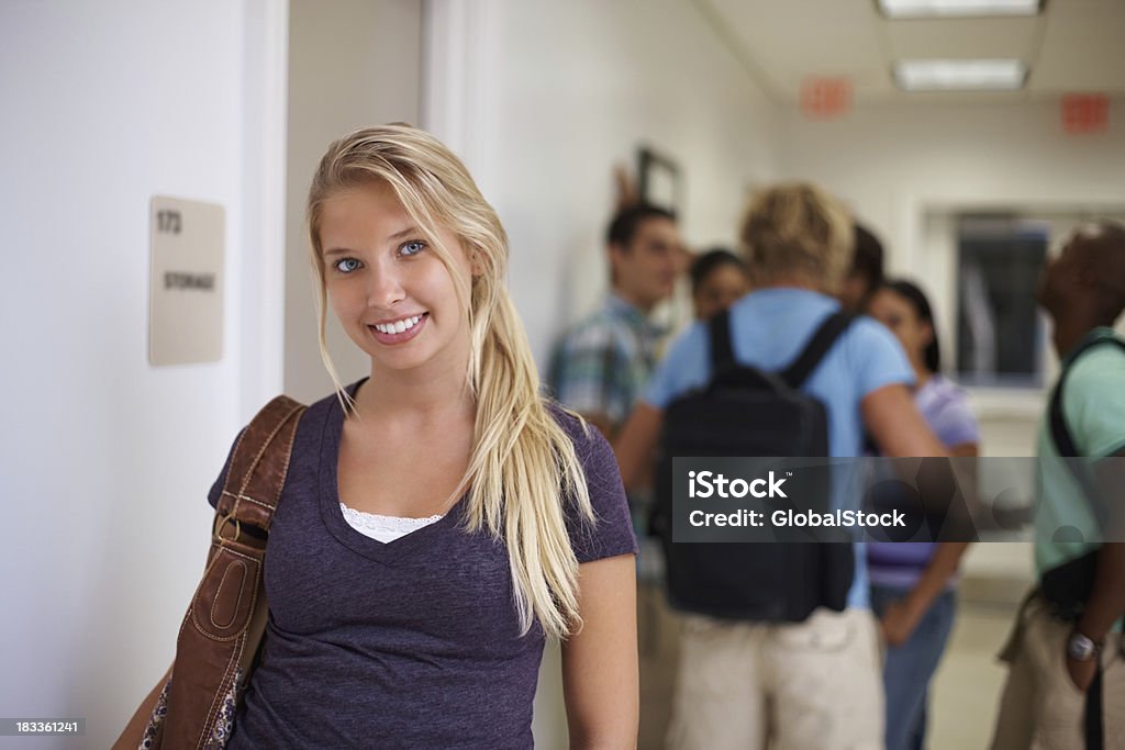 Pretty young student with her classmates in background Portrait of pretty young student with her blur classmate in background 20-29 Years Stock Photo