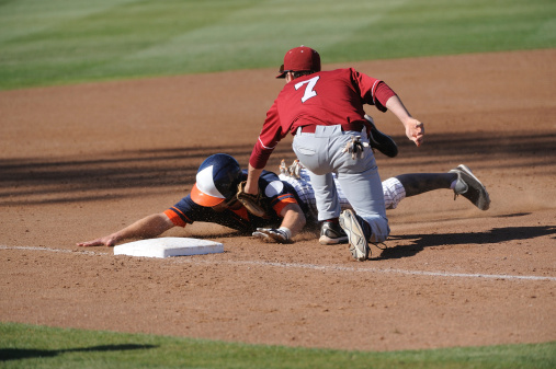 A Baseball player gets tagged out at third base.