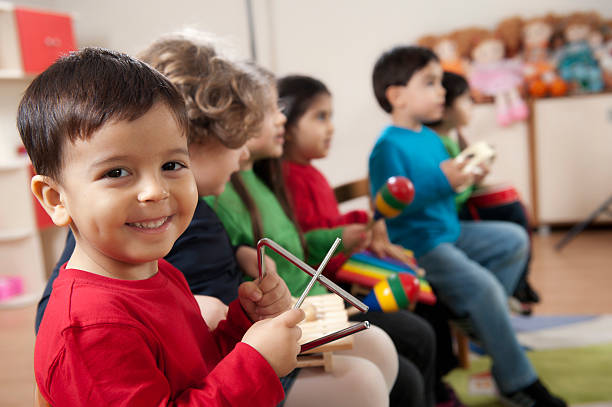 Preschool age children in music class Little boys portrait.A group of preschool children in a music class. triangle percussion instrument stock pictures, royalty-free photos & images