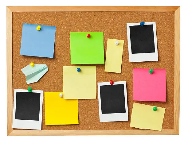 "Office cork board with colorful notes,polaroid photos attached by thumbtacks isolated on white. For designer usage."