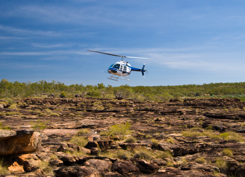 A helicopter coming in to land at the top of Mitchell Falls.