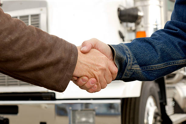 Transportation Handshake A royalty free image from the trucking and transportation industry of two truck drivers shaking hands. transporter stock pictures, royalty-free photos & images