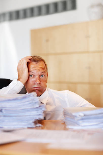 istock Exhausted clerk sitting with head in hand 183362740