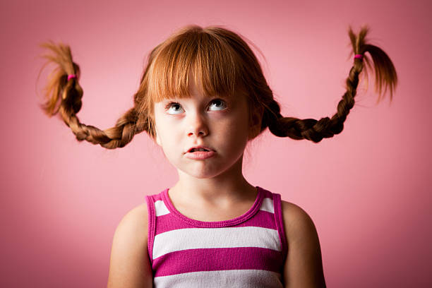 istock Red-Haired Girl with Upward Braids on Pink Background 183362932