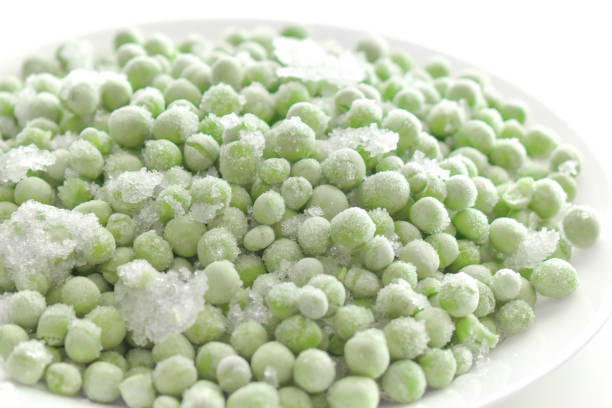 istock Frozen green peas on a white plate. 1833634336