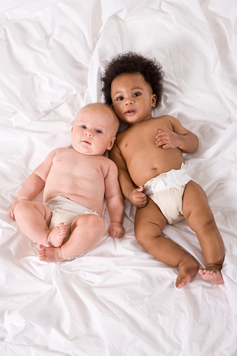 Multiracial babies lying together side by side, 4-6 months old