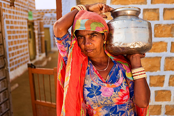istock Indian woman carrying water from well 183364034