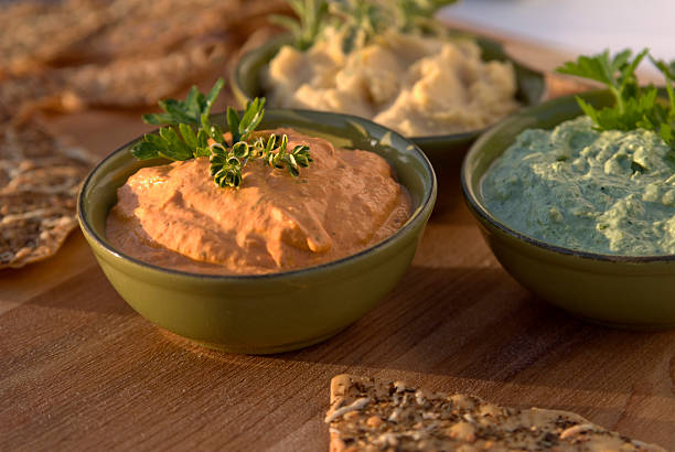 Roasted red bell pepper and vegetable herb hummus on a table
