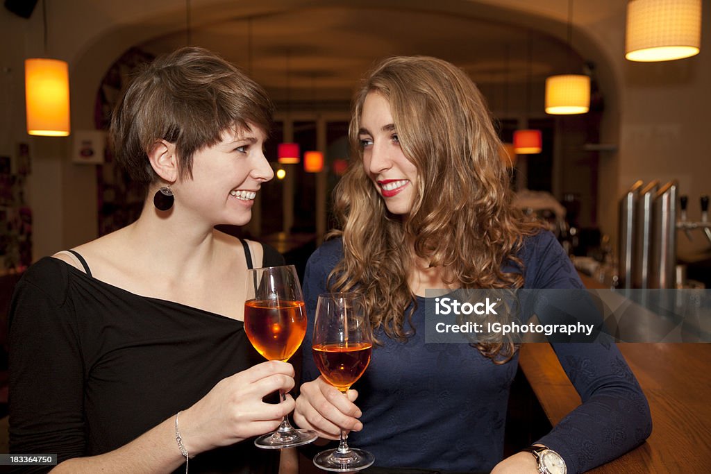 Due giovani donne brindando con vino Prosecco Bicchieri da Bar - Foto stock royalty-free di Abbigliamento casual