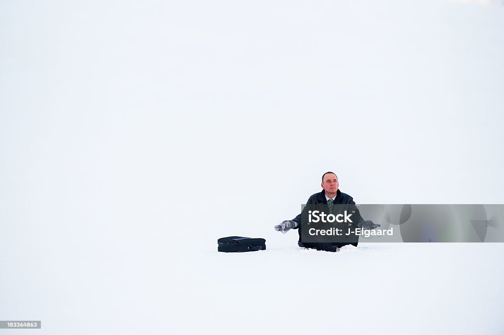 Empresario Meditando o concentrarse en tormenta de nieve - Foto de stock de Con las piernas cruzadas libre de derechos