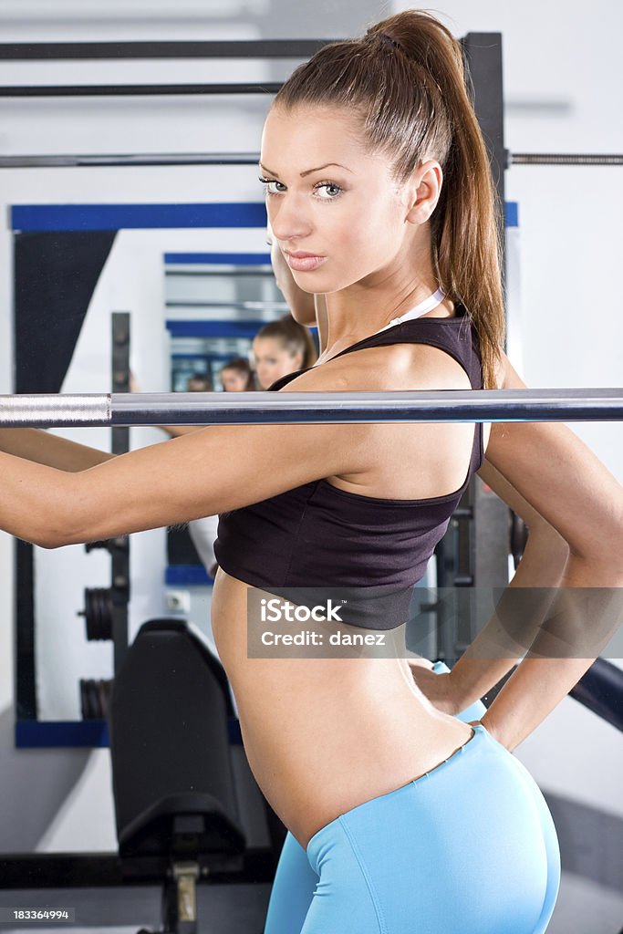 Giovane e sana ragazza nel fitness club - Foto stock royalty-free di Abbigliamento sportivo