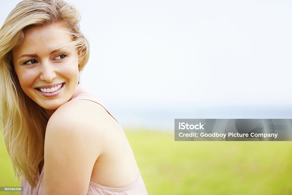 Uśmiechający się kobieta Patrząc na copyspace - Zbiór zdjęć royalty-free (Bliski)