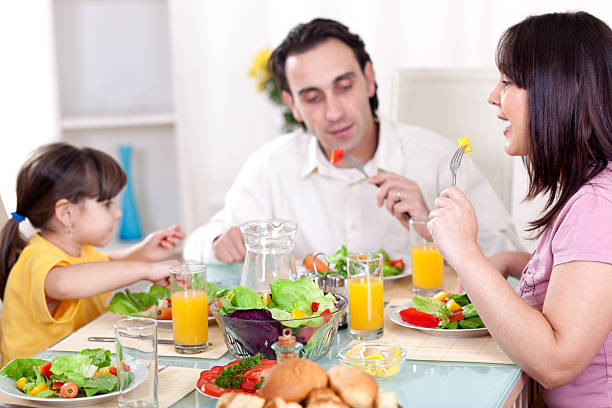 istock Happy family eating vegetables for lunch together 183365780