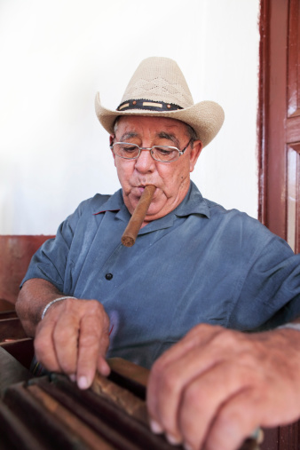 Old cuban man rolling cigars