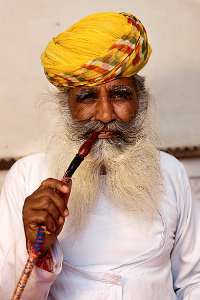 istock Old Indian man smoking water pipe. 183366786