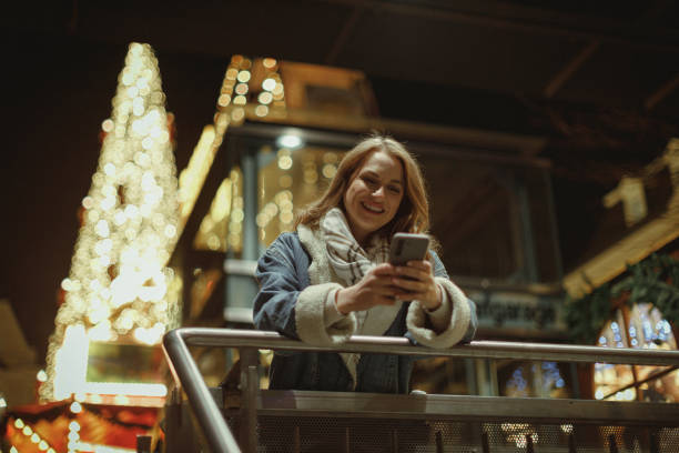 istock Happy woman using a smartphone during Christmas holiday in the city 1833683051