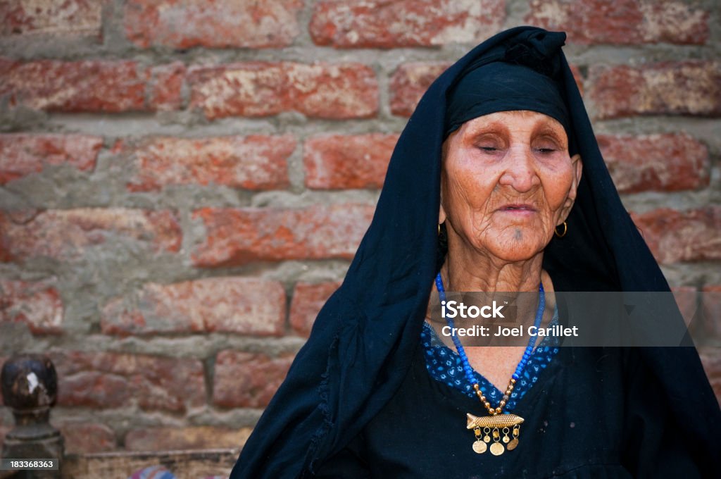 Very senior Arab woman outside home in Luxor, Egypt A 110-year-old Egyptian woman, still sharp in mind and energy, in Luxor, Egypt Egyptian Ethnicity Stock Photo