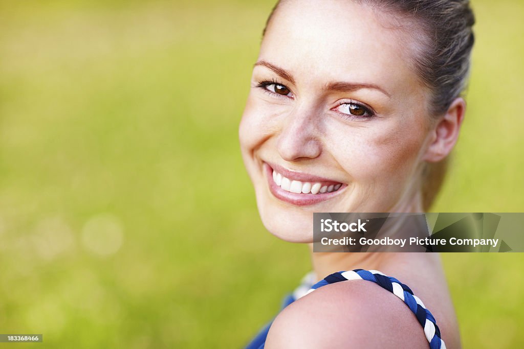Una bella donna sorridente su sfondo verde - Foto stock royalty-free di Abbigliamento casual