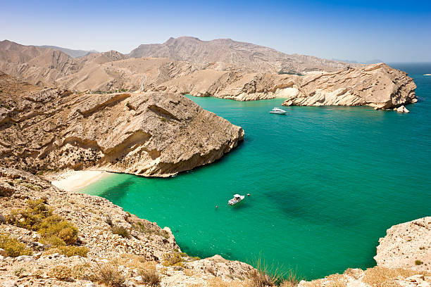 Beautiful Oman Coast Green Lagoon with Hidden Beach "Beautiful green-blue lagoon with hidden beach between harsh rocks at the coast of Oman. Rocky Coast of Sultanate Oman, Arabia." persian gulf countries stock pictures, royalty-free photos & images