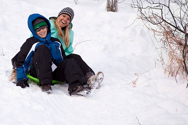 istock Mother and son playing on snow sled 183369316