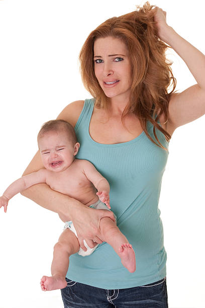 istock Frustrated mother holding her cry baby 183369696