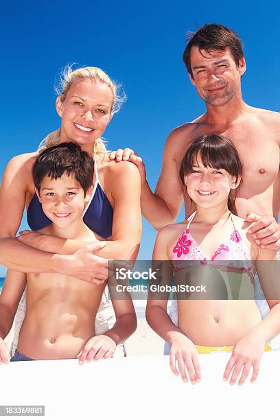 Famiglia Con Un Cartello Di Godendo Le Loro Vacanze - Fotografie stock e altre immagini di Famiglia
